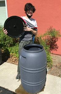 Student standing behind compost bin