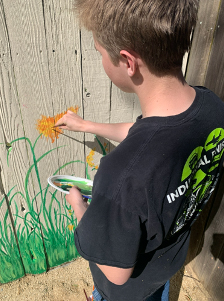 Student painting fence
