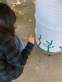 Girls painting trash can