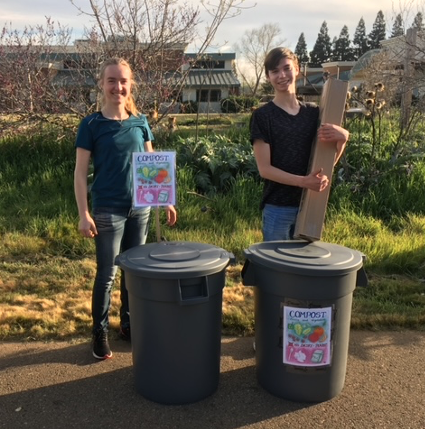 Students standing behind composting bins