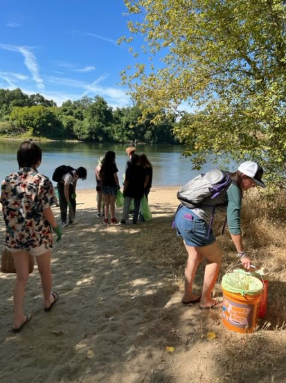 Group of students cleaning up beside river