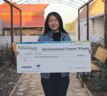 Girl holding 500 dollar cheque for environmental contest winner